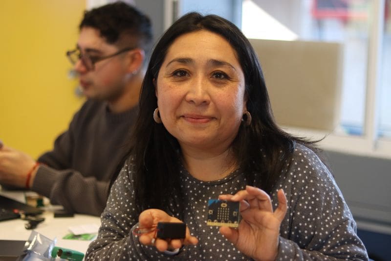Foto de una Docente primera vez experimentando con un BBC micro:Bit en capacitación de San Nicolás Diácono de Santiago.